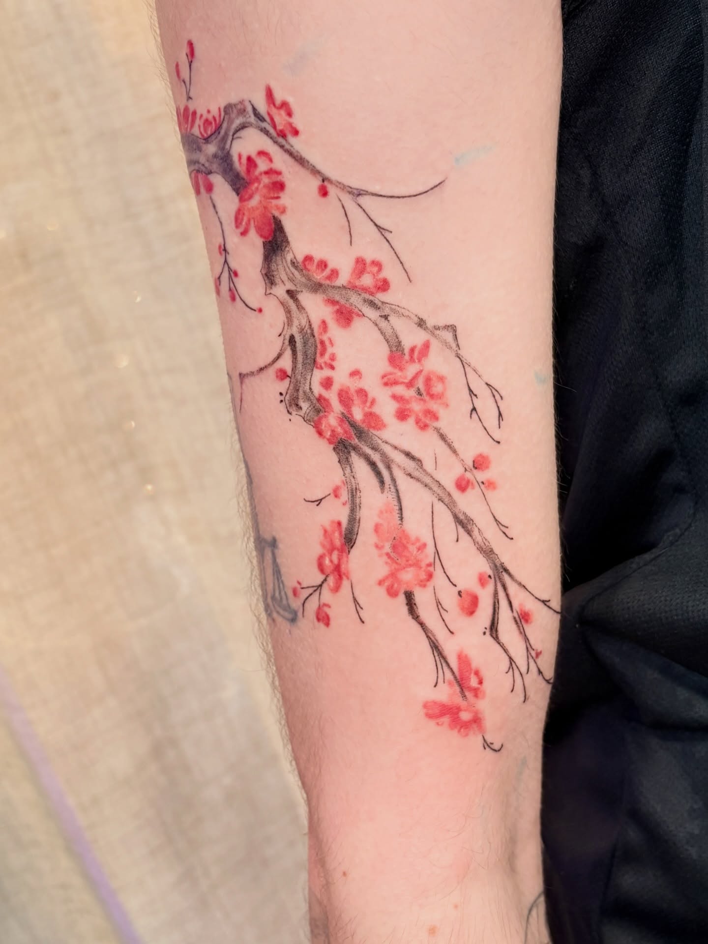 Branche fleurie rouge en tatouage